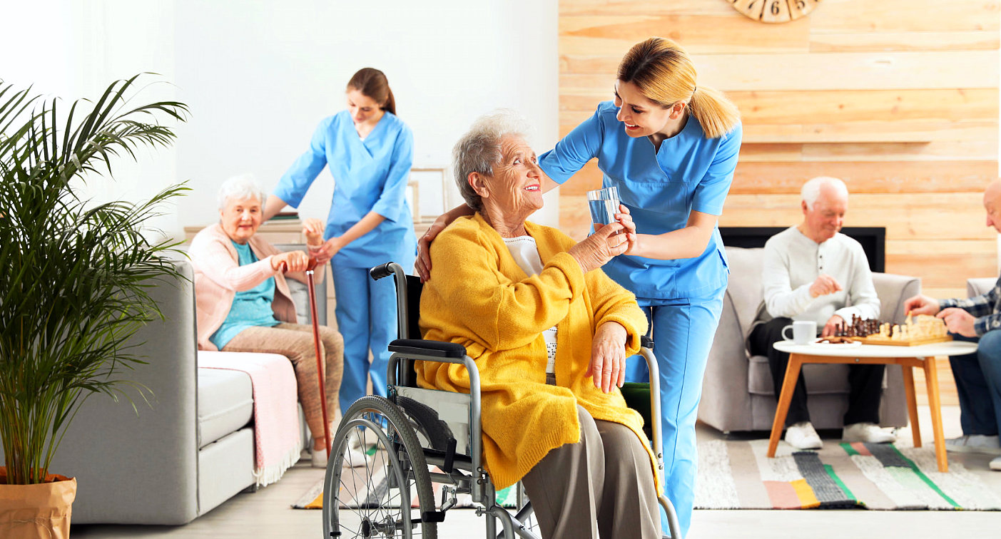 caregiver giving a glass of water to senior woman