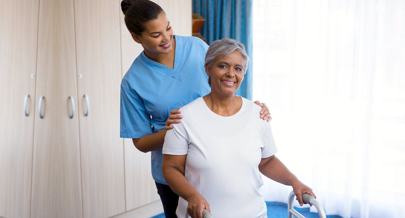 caregiver looking at senior woman while smiling