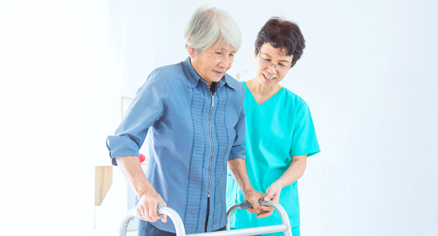 caregiver assisting senior woman in walking