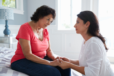 adult woman comforting another adult woman