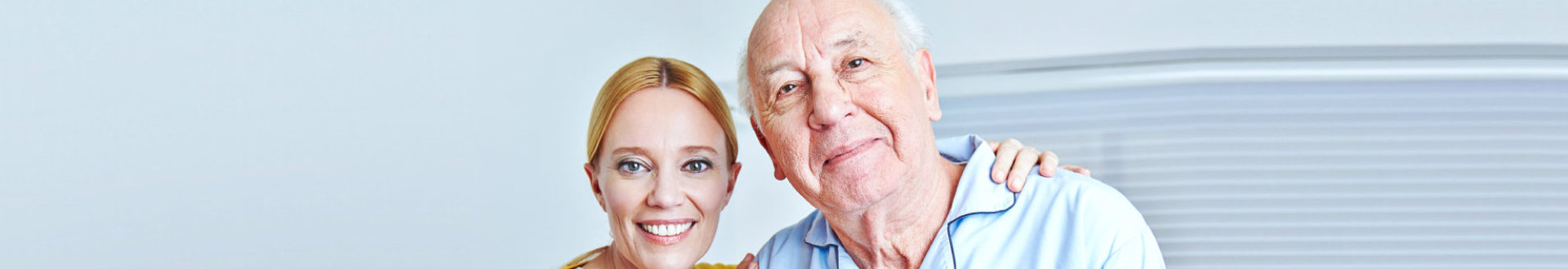 caregiver and senior man are smiling