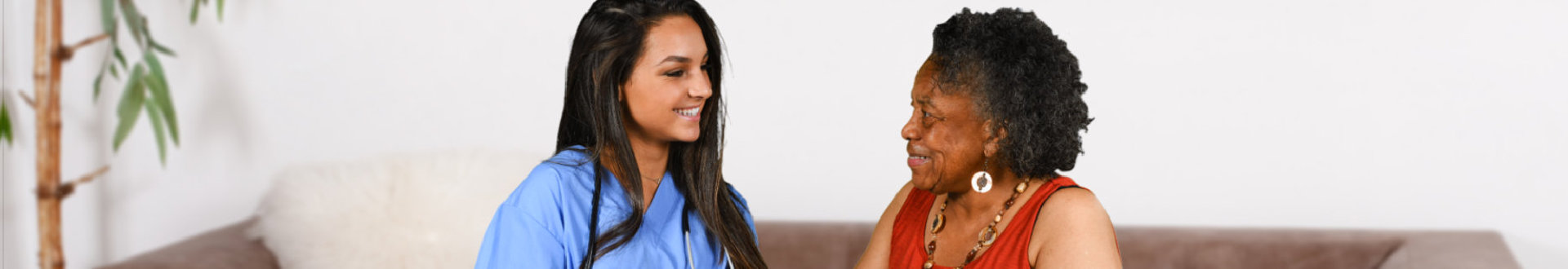 caregiver and senior woman are looking at each other